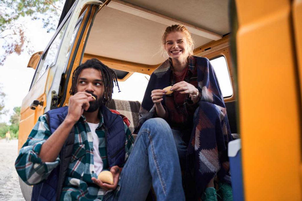 Couple sitting in a van eating chips
