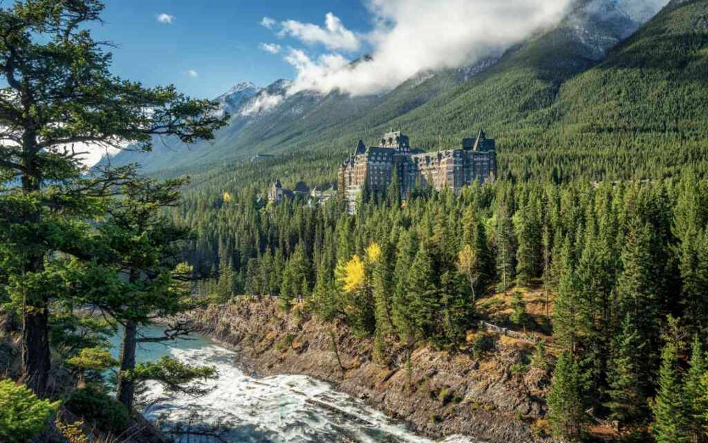 Large hotel against mountains with a river running in front
