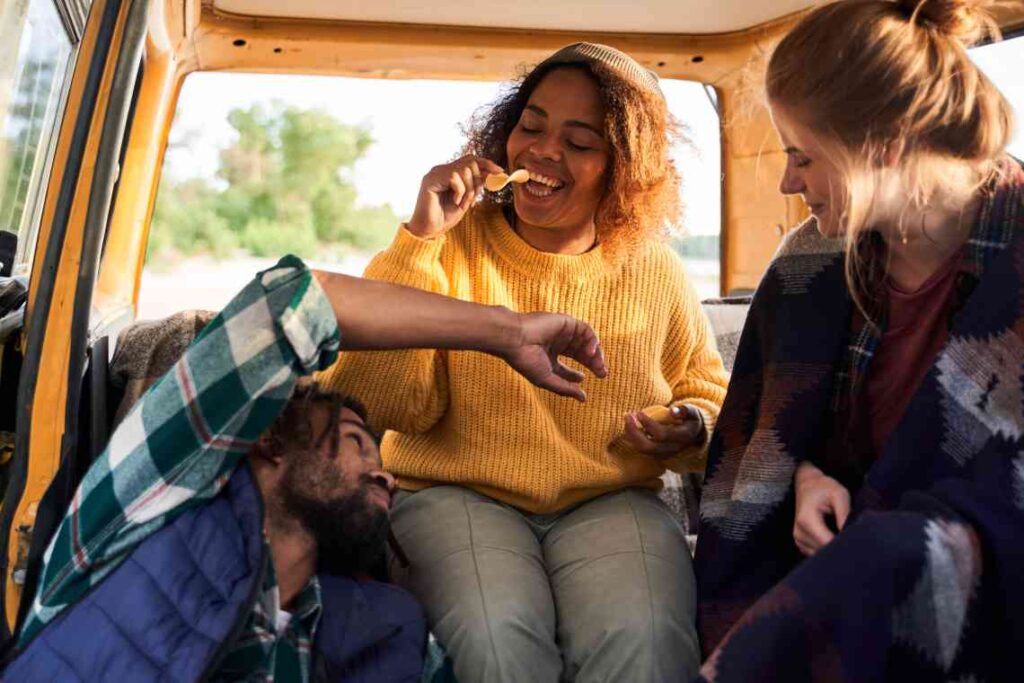 3 friends in a van eating chips