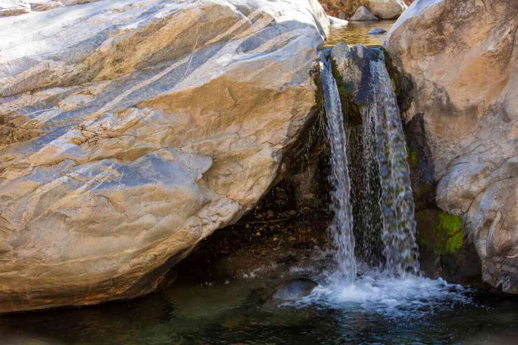 small waterfall between gray granite rock walls 