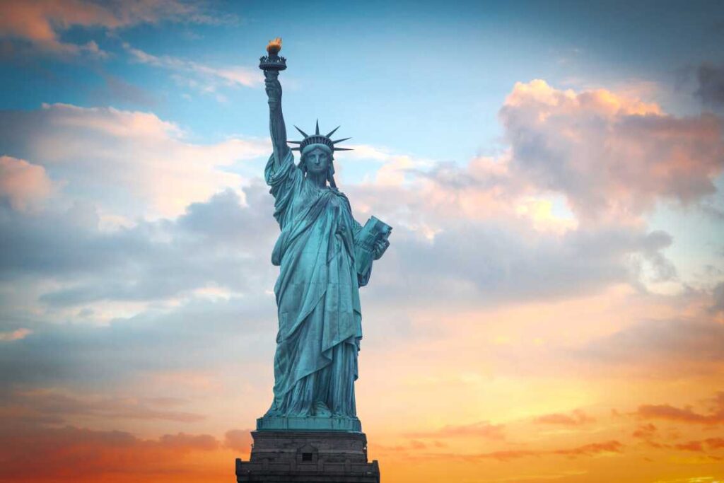 Close up of Statue of Liberty at sunset with blue and gold clouds behind