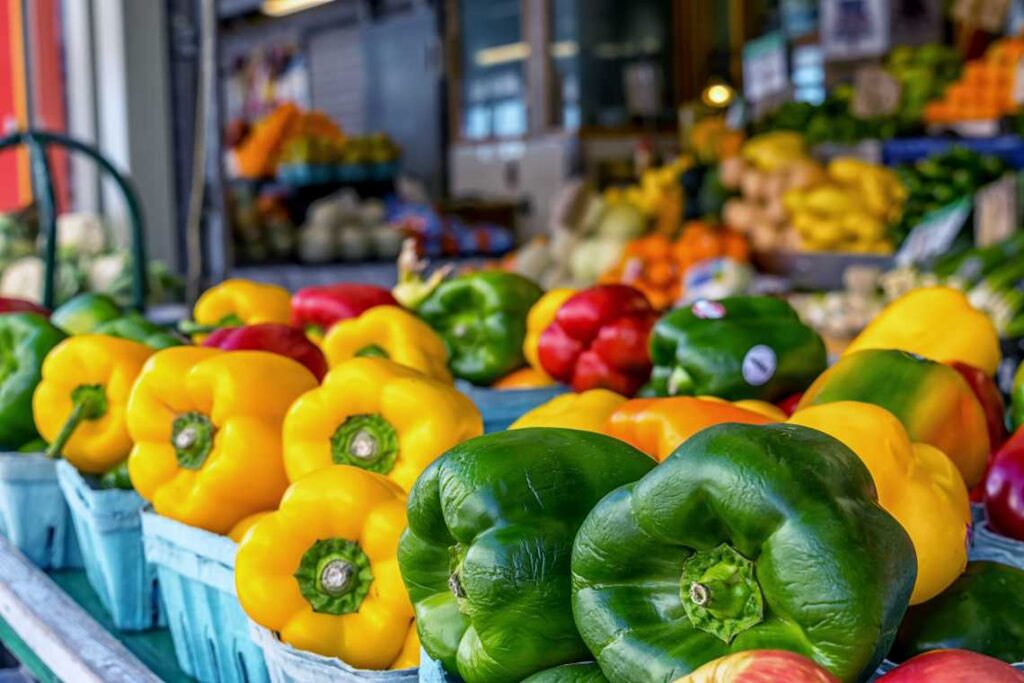 red, yellow and green bell peppers outside at findlay market in cincinnati