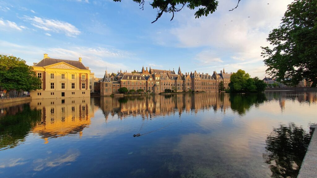 The Mauritshuis Museum and Dutch Houses of Parliament by a calm lake in The Hague, Netherlands.
